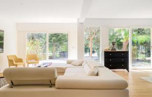 a living room with four white couches and windows at Spacieuse Maison De Ville in Étaples
