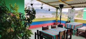 奥塔瓦洛Green House Araque Inn的餐厅设有桌椅和色彩缤纷的墙壁