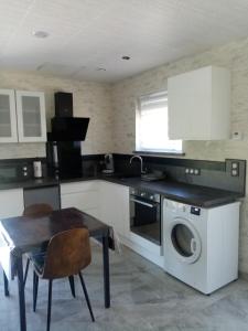 a kitchen with a table and a washer and dryer at Le doux refuge 67 in Schwabwiller