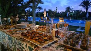 une table avec des amuse-gueules, des assiettes et de la nourriture dessus dans l'établissement Villa Fima Kech, à Marrakech