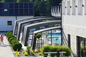 a woman walking by a pool in a resort at Domki OLIVIA in Darlowko