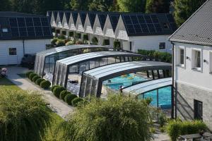 an overhead view of a swimming pool with solar roofs at Domki OLIVIA in Darlowko