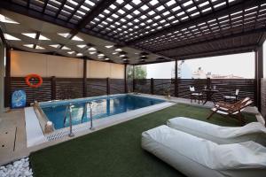 a swimming pool in a house with a couch at Rafina Splendor in Rafina