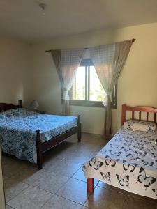 una camera da letto con due letti e una finestra di Apartamento amplo 300m da praia a São Lourenço do Sul