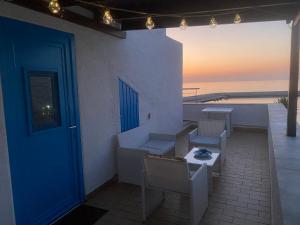 un patio con puerta azul, mesa y sillas en Baia Marina Oasi, en Balestrate