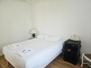 a bedroom with a white bed with two towels on it at Appartement trois chambres avec jardin in Montboucher-sur-Jabron
