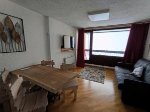a living room with a wooden table and a couch at Résidence Chalmettes - Joli studio rénové avec accès direct aux pistes. parking MAE-8704 in Montgenèvre