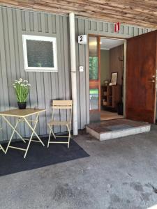 a table and chairs sitting outside of a building at Kattugglans Gästrum 2 in Ljungby