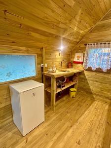 a kitchen with a sink and a refrigerator in a cabin at Aos Pés do Gigante in Joanópolis +19 photos