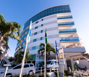 Comfort Suites Macaé في ماكاي: مبنى فيه سيارات تقف امامه