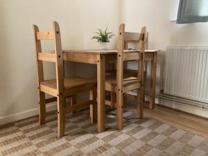 a wooden table and chairs with a plant on it at HARMONY House in Whitley