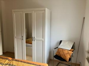 a bedroom with a closet and a chair with a bed at Apartment in Osnabrück in Osnabrück