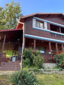 a brown house with a porch and flowers on it at Casa Melania in Eşelniţa