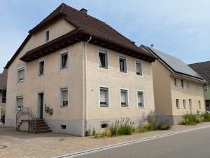 a large brick building with a brown roof at ARCOS Apartment - Geräumige 3-Zimmer-Wohnung mit 8 Einzelbetten - Perfekt für Familien, Gruppen oder Monteure in Kappel-Grafenhausen