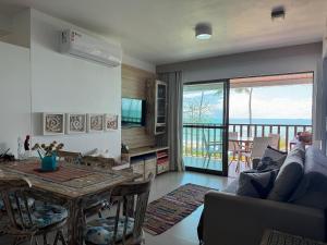 a living room with a table and a view of the ocean at Baobá Residence Porto de Galinhas Beira Mar na Vila in Porto De Galinhas