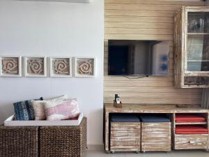 a living room with a tv and a couch at Baobá Residence Porto de Galinhas Beira Mar na Vila in Porto De Galinhas