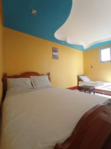 a bedroom with a large white bed with a blue ceiling at Sunset rooftop Rabat Sale Airport in Sale