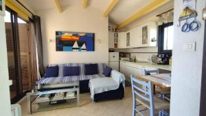 a kitchen with a couch and a table in a room at Appartement T2 dans village Naturiste en bord de mer in Leucate-Plage