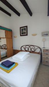 a bedroom with a white bed with a wooden frame at Appartement T2 dans village Naturiste en bord de mer in Leucate-Plage +34 photos