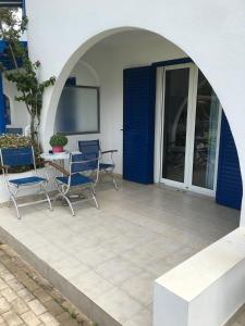 a patio with two chairs and a table in front of a house at Saltriver rooms in Almiropótamos
