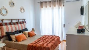 1 dormitorio con 1 cama con almohadas de color naranja en Pandora House, en Nazaré 31 fotos más
