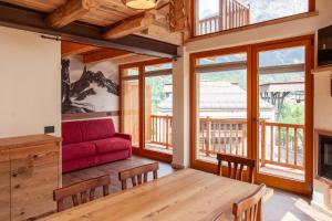 een woonkamer met een rode bank en een tafel bij Méijon Salluard RTA in Courmayeur