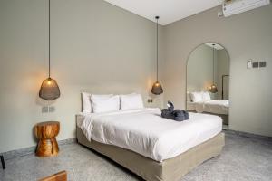 Un dormitorio con dos camas y un espejo. en Sabi San 15C - Relax and Recharge - 2BR Villa - Private Pool - Stylish, en Kerobokan