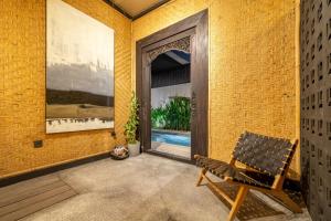 Una habitación con una puerta y un banco al frente. en Sabi San 15C - Relax and Recharge - 2BR Villa - Private Pool - Stylish, en Kerobokan