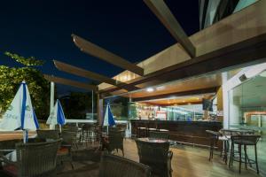 a restaurant with chairs and tables and blue umbrellas at Royal Kingdom Macaé in Macaé +68 photos