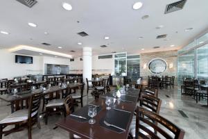 a dining room with wooden tables and chairs at Royal Kingdom Macaé in Macaé