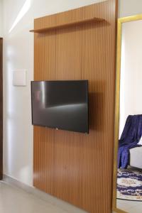 a flat screen tv hanging on a wooden wall at Apartamento novo com garagem e ar condicionado in São Lourenço