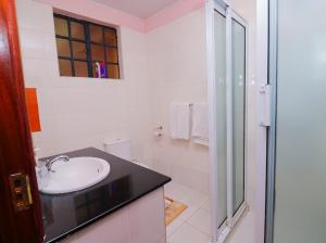 a white bathroom with a sink and a shower at St Helen lane Karen in Nairobi +13 photos