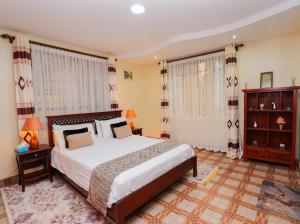 a bedroom with a large bed and two windows at St Helen lane Karen in Nairobi