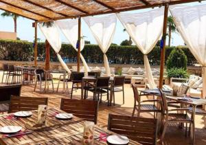 a restaurant with tables and chairs on a patio at Villa El Paraiso - Near Es Trenc in Campos