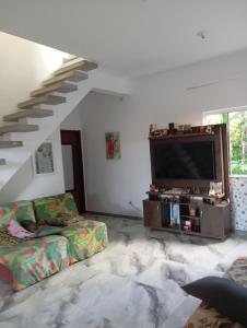 a living room with a couch and a flat screen tv at Marta's house in Peruíbe