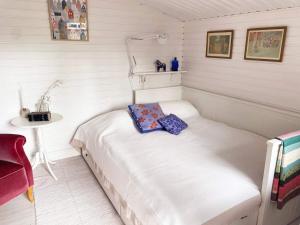 a small white room with a bed and a table at 7 person holiday home in Mönsterås in Mönsterås