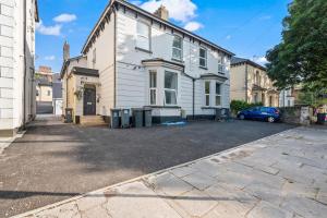 an empty parking lot in front of a white house at Cinema Studio Room with Spa Facilities For Couples in Cardiff +10 photos