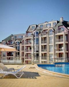 a large apartment building with a swimming pool in front of it at Apartment Skу in Kavarna
