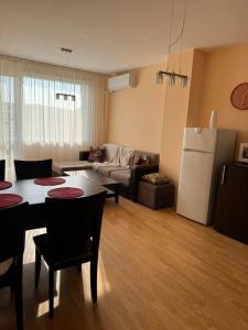a kitchen and living room with a table and a refrigerator at Apartment Skу in Kavarna