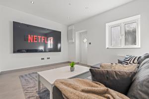 a living room with a couch and a tv at Cinema Studio Room with Spa Facilities For Couples in Cardiff