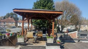 a wooden pavilion with two chairs and a table at Comfy Studio - Sleeps 2 Near Warwick University in Coventry