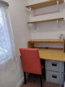 a desk and a red chair in a room at Comfy Studio - Sleeps 2 Near Warwick University in Coventry