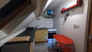 a small kitchen with a sink and a red stool at Comfy Studio - Sleeps 2 Near Warwick University in Coventry