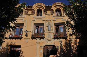 un edificio con ventanas y balcones con flores. en Casa Grande, en Villarroya de la Sierra