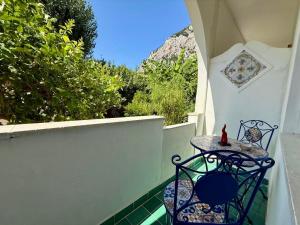 Una mesa y sillas en un balcón con vista. en Eliza Art, en Capri