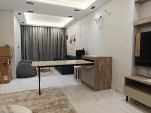 a room with a desk and a couch and a television at Hotel Apt, in a Compound, Cairo central Location, Maadi Mokattam New Cairo in Cairo