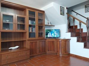 a living room with a large wooden entertainment center at Casa Fasano in Miranda