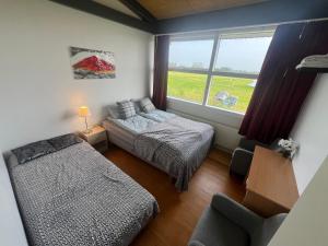 ハヴォルスヴォルールにあるGodaland Fljotshlidのベッドルーム1室(ベッド2台付)、景色を望む窓が備わります。 +7枚の写真