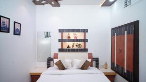 a bedroom with a bed with white sheets and pillows at Raahi - 3 Bedroom Flat Near Kashi Vishwanath in Varanasi