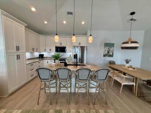 een keuken met een tafel en stoelen en een keuken met witte kasten bij New Build - Pool - Walk to Beach in Fort Myers Beach +28 foto's